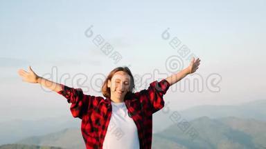 年轻迷人的白种人黑发女子站在山顶，微笑着与山景的背景。 Fema